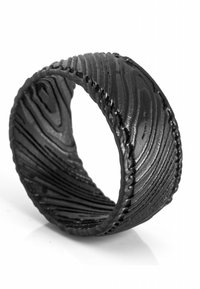 Schwarzer Ring aus strukturiertem Material mit Holzmaserung. Das Design weist geschwungene Linien und eine glatte Innenfläche auf.