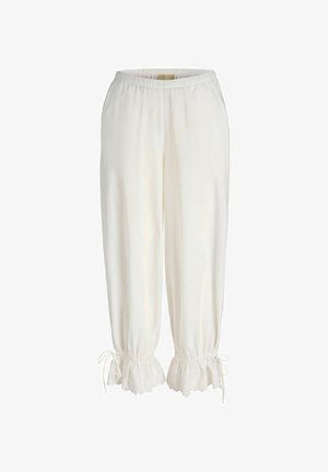 Weiße lockere Hose mit elastischem Bund und mit Spitzenrüschen an den Bündchen, die an den Knöcheln mit kleinen Schleifen gebunden sind.