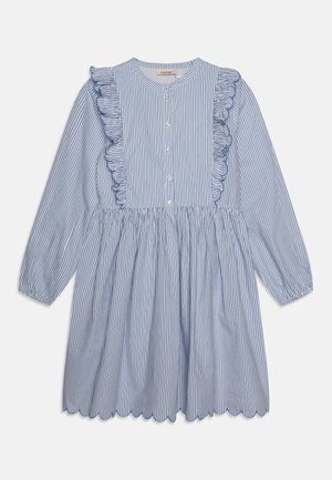 Vestido de rayas azul y blanco con volantes a lo largo de la botonera, mangas largas y dobladillo en picos. Hecho de una tela ligera.