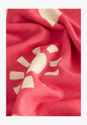 Korall színű textil, puha tapintással, fehér napmintával és szabálytalan formákkal. Az anyag könnyű és enyhén rugalmas.