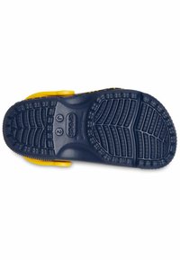 Semelle en caoutchouc bleue avec des motifs de grip texturés, présentant des accents jaunes et un design large et ouvert pour la ventilation.