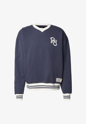 Tengerészkék V-nyakú pulóver, fehér díszítésekkel, bordázott mandzsettákkal és szegéllyel. A mellrészen hímzett logó, az alján pedig címke található.