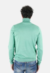Maglione a collo alto verde menta in morbido misto cotone a costine; design aderente con maniche lunghe e colletto e orlo a costine a contrasto.