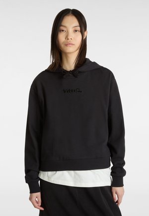 Sweatshirt à capuche noir avec un design court, cordon de serrage et logo "vans." en relief sur le devant, superposé sur une chemise blanche.