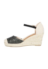 Espadrillas a zeppa in fibra naturale nere con cinturino alla caviglia. Forma curva, tomaia in tessuto texturizzato e tacco avvolto in juta.