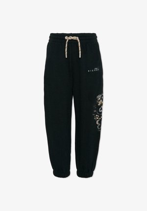 Pantalon de survêtement noir avec taille élastique et cordon de serrage. Orné d'embellissements dorés et argentés sur une jambe. Poignets aux chevilles. Matière douce.