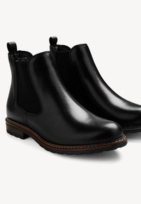 Botas Chelsea de cuero negro con paneles elásticos en los laterales, tiradores, puntera redondeada y un tacón de madera con un detalle de costura en contraste.