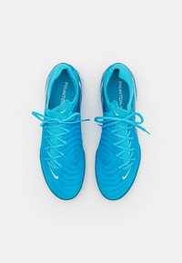 Modré syntetické kopačky na fotbal s texturovaným svrškem, plochými tkaničkami a bílým logem Nike. Disponují nízkým designem a polstrovaným jazykem pro větší pohodlí.