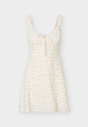 Rochie de vară albă fără mâneci, cu model floral galben, decolteu pătrat, bretele adunate la umeri și detaliu cu fundă în față.