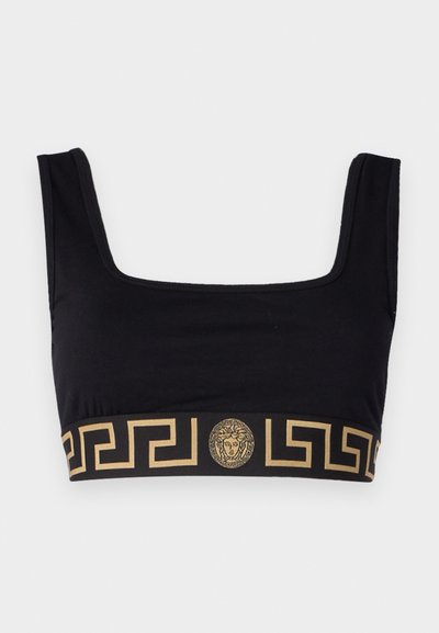 Schwarzes Croptop mit quadratischem Ausschnitt, aus glattem Material gefertigt. Verfügt über ein golden gemustertes Band und eine Medaillonverzierung am Saum.
