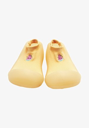 Zapatos de slip-on amarillos de punto con parte superior texturizada, que presentan un pequeño motivo de sandía bordado y una suela de goma lisa.