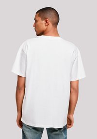 White cotton t-shirt with short sleeves, crew neck, and relaxed fit, viewed from the back against a plain background.