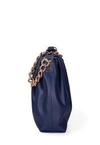 Marineblauwe leren handtas met textuur en gouden kettingriem, zijkant zichtbaar tegen een witte achtergrond.