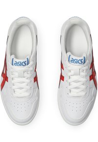 Białe buty sportowe z czerwonymi i czarnymi akcentami. Gładka tekstura, okrągły nosek, sznurowany fason oraz perforowane detale na przodzie.