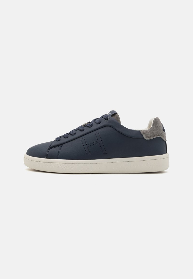 Mörkblå lädersneakers med rund tå, grå mockaaccenter vid hälen, strukturerad sula och ton-i-ton-söm. Har logotyp på sidan.