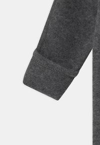 Grauer Baumwollmischgewebe, das mit einem umgeschlagenen Bund und sichtbaren Nähten, weicher Textur und glattem Finish versehen ist.