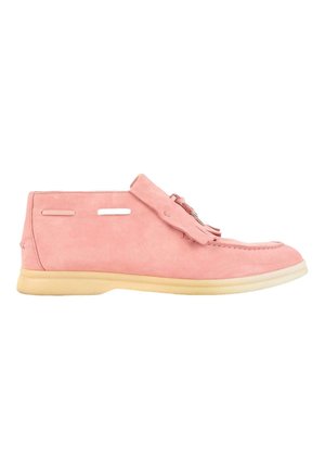 Mocassin en daim rose clair avec semelle en caoutchouc beige, pompon décoratif sur le dessus et détails cousus le long des bords, vue de côté.