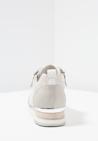 Szare zamszowe buty z fakturowaną cholewką, koturnem z korka oraz metalicznymi akcentami z tyłu. Posiadają zamek błyskawiczny jako detal.