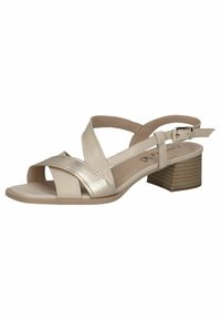 Sandalo beige con cinturino slingback, fasce incrociate metalliche, punta aperta e tacco a blocco modesto, dotato di suola testurizzata e fibbia per caviglia regolabile.
