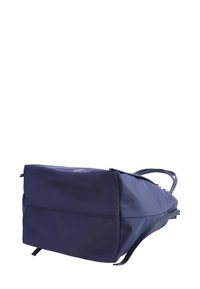 Mochila navy de forma rectangular, hecha de material suave. Presenta correas ajustables y un detalle de costura a lo largo de la parte trasera.