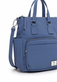 Blue ribbed tote bag with dual top handles, removable shoulder strap, front zip pocket, and silver-tone hardware accents.