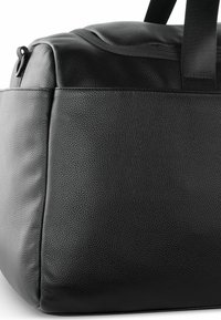 Sac de sport en cuir noir avec une surface texturée, de forme rectangulaire, poignées doubles et coutures renforcées. Aucun matériel ou accent notable visible.