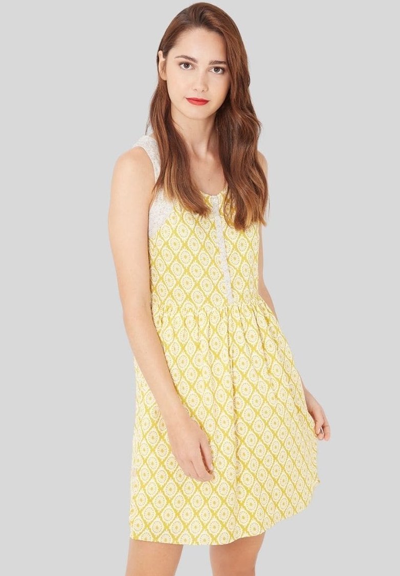 Vestido amarillo con un patrón de diamantes, diseño sin mangas, cintura elástica y detalles de encaje en los hombros. Textura de tela suave.
