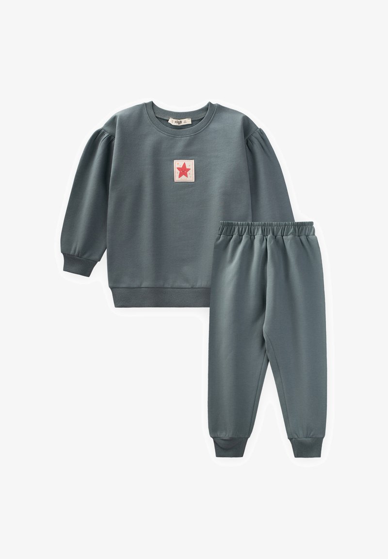 Detský dvojdielny outfit v tlmenej modrej farbe, ktorý obsahuje mikinu s dlhým rukávom a červeným hviezdovým nášivkom a zodpovedajúce jogger nohavice s elastickým pásom.