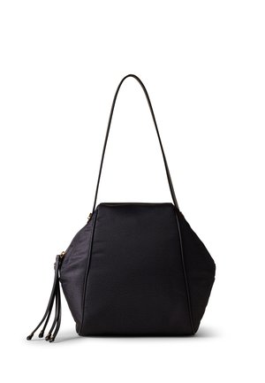 Black faux leather bag with a geometric shape, featuring a long strap, zip closure, and decorative fringe details. Smooth texture with accents.