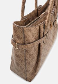 Brązowa torba typu tote o wzorzystej fakturze, wyposażona w podwójne uchwyty, kieszeń na zamek oraz ozdoby w kolorze złotym.