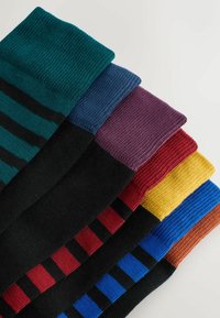 Fem par sorte sokker med farvede kanter og matchende vandrette striber i grøn, blå, lilla, rød, gul og brun.