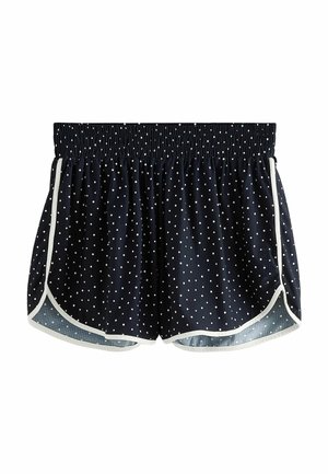 Short de sport bleu marine à pois blancs, taille élastique, bordure blanche le long de l’ourlet courbé et des coutures latérales.