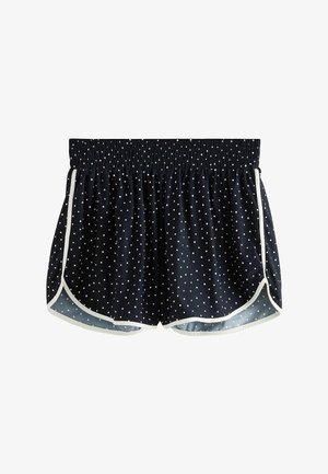 Short de sport bleu marine à pois blancs, taille élastique, bordure blanche le long de l’ourlet courbé et des coutures latérales.