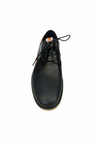 Zapato de cuero negro con una textura suave, punta redonda y diseño de cordones. Presenta perforaciones sutiles en los laterales y un interior marrón.