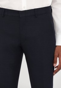 Námořnické kalhoty z texturované látky, slim fit, s poutky na opasek a plochým předním designem, kombinované s bílou košilí s knoflíky.