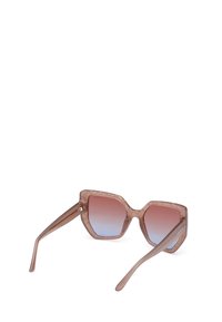 Lunettes de soleil hexagonales avec une monture translucide de couleur brun clair et des verres dégradés passant du rose au bleu. Elles possèdent des branches fines avec des accents subtils.