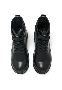 Botas de tobillo de cuero negro con exterior texturizado, punta redonda, gruesos cordones negros y sutilezas de costura blanca alrededor de la suela.