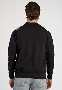Czarny sweter dzianinowy z ribbowanym kołnierzem i mankietami, teksturowanym tyłem, elastycznym dołem oraz szarymi akcentami na ramionach. Styl casualowy, dobrze dopasowany.