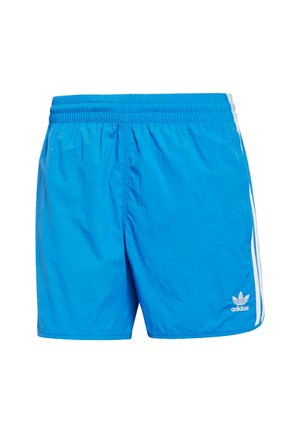 Mėlynos sportinės šortai, pagaminti iš lengvos medžiagos, su elastingu juosmeniu, turintys baltas šonines juostas ir mažą adidas logotipą ant apatinio krašto.