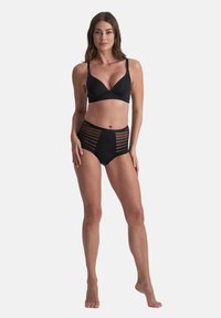 Set di bikini nero con reggiseno a scollo profondo e spalline regolabili, e slip a vita alta con accenti in mesh a righe orizzontali.