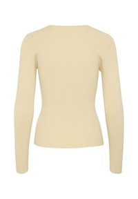 Ribbade långärmade toppar i ljus beige, med en figurnära silhuett och båthals. Tillverkad av ett mjukt, texturerat stickat tyg.