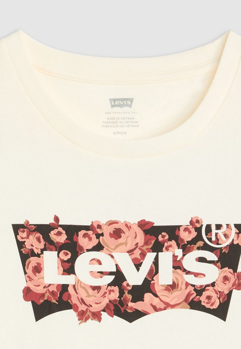 Cremfarbendes T-Shirt mit einem schwarzen Grafikdesign, pinken Rosen und weißem "Levi's"-Schriftzug. Runder Ausschnitt und weicher Baumwollstoff.