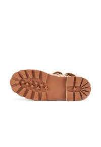 Smeđi gumeni potplat s robusnim uzorkom gazećeg sloja, s izbočenim zvjezdastim detaljima i dubokim utorima za prianjanje. Glatke ivice i čvrsta konstrukcija.