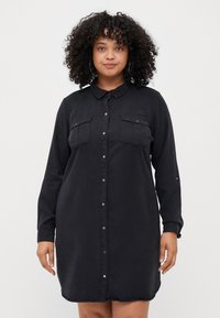 Black button-up shirt dress with long sleeves, two chest pockets, a collared neckline, and a straight cut, made of lightweight fabric.