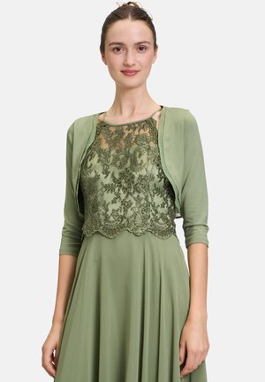 Grünes Kleid mit einer Spitzenüberlage, floralem Stickereien und gewelltem Saum. Kurze Ärmel und glattes Material sorgen für einen schichtartigen Look.