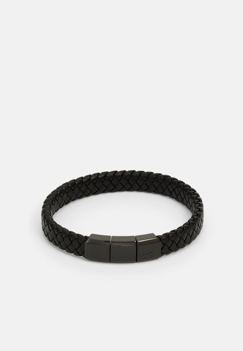 Svarte flettede lærarmbånd med tre stilige metallakkenter, rektangulær form og en teksturert overflate. Justerbar passform for komfort.