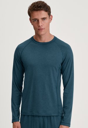 Teal lange mouw shirt met een ronde halslijn, gemaakt van textuurstof. Heeft raglanmouwen en een relaxte pasvorm. Eenvoudig ontwerp zonder patronen.