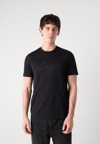 Černé tričko vyrobené z bavlny s krátkými rukávy, s vyraženým logem "Boss" na hrudi. Hladká textura, design s kulatým výstřihem.