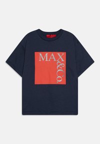 Tumed lühikeste varrukatega T-särk korallpunase ruudukujulise graafikaga, millel on hõbedaste tähtedega "MAX & Co." Pehme kangas, ümar kaelus, lõdva istuvusega.