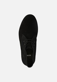 Chaussure à lacets en suède noir avec un bout rond, des détails de couture subtils et une texture douce. L'intérieur présente une doublure noire uni.